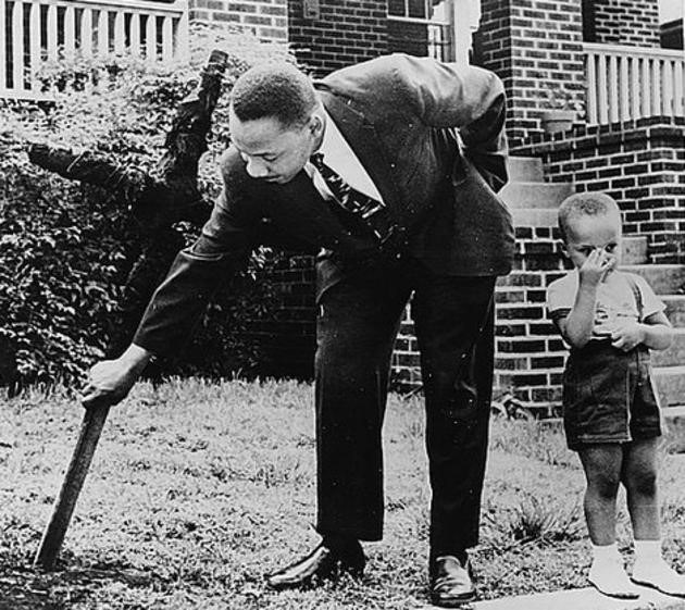 Martin Luther King, Jr. (with his son by his side) removing a burnt cross from his front yard in Atlanta, Georgia in 1960.