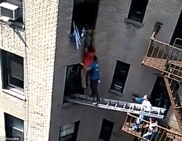 Workers on a fire escape risked their lives to help rescue a man from the fifth floor of a burning New York apartment building.